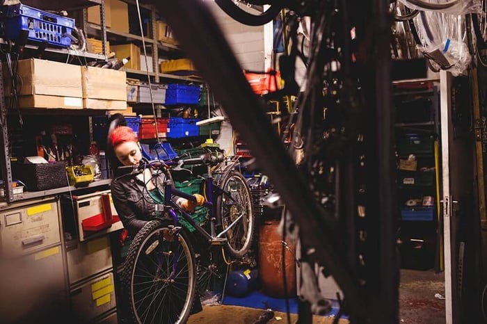 Mechanic Working on Bicycle in Bike Storage Unit