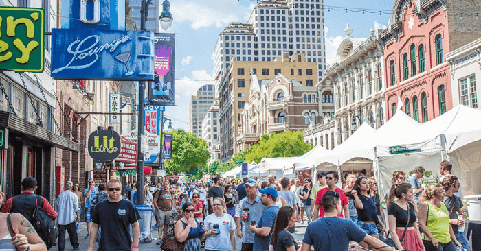 Austin residents walking around a downtown festival with pop-up tents