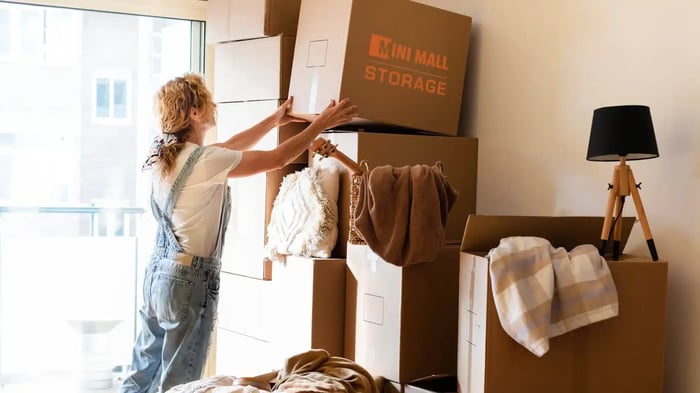 a woman putting seasonal items in Mini Mall Storage moving boxes