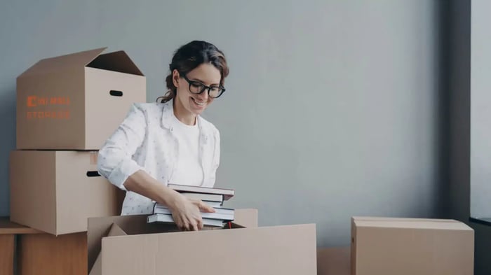 a student storing books in moving boxes
