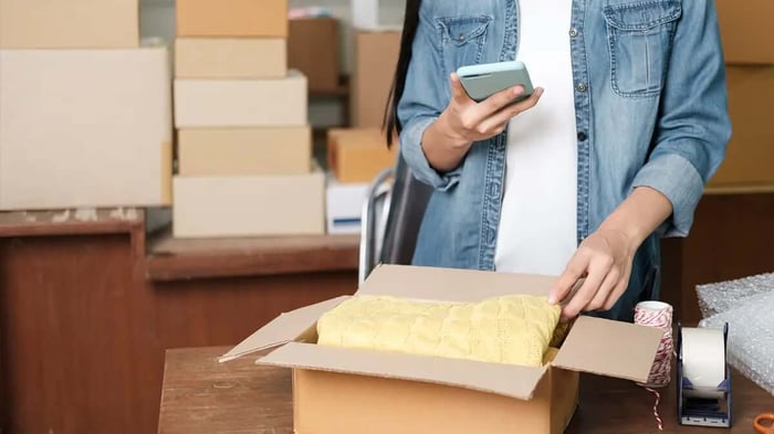 a business owner packing things in boxes for storage