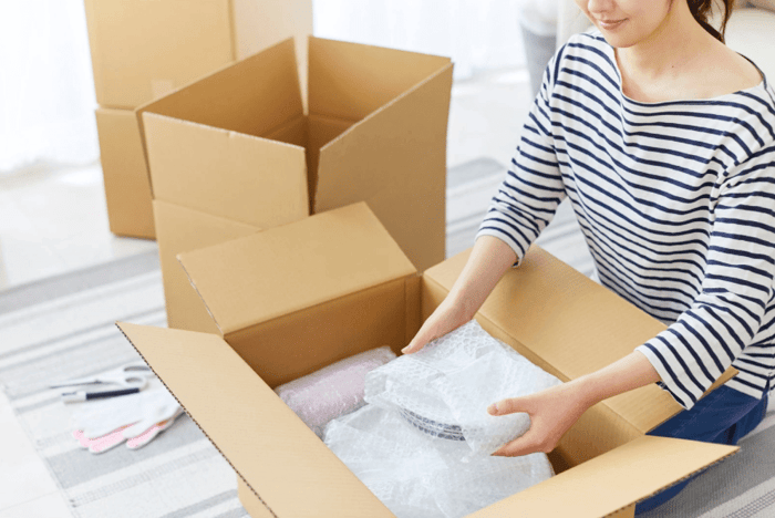 Woman packing boxes with self storage materials