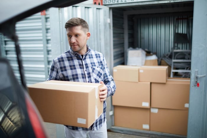 man loading boxes into a drive up storage unit