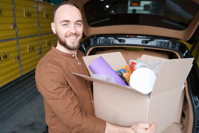 Man holding box spring cleaning with self storage Clemmons, NC