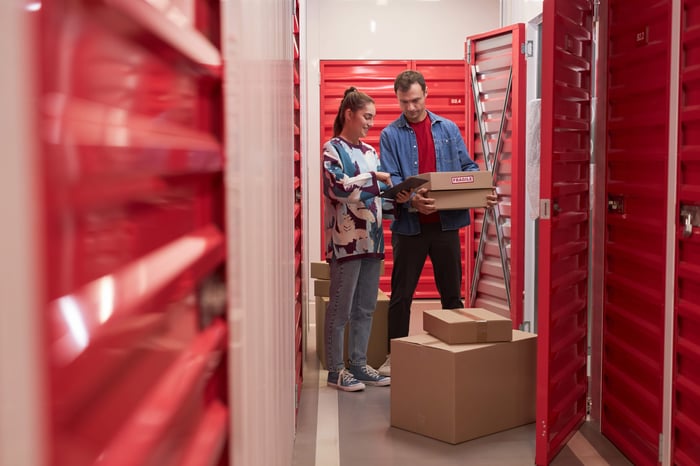 How to choose a storage unit with customers organizing boxes inside a self-storage facility