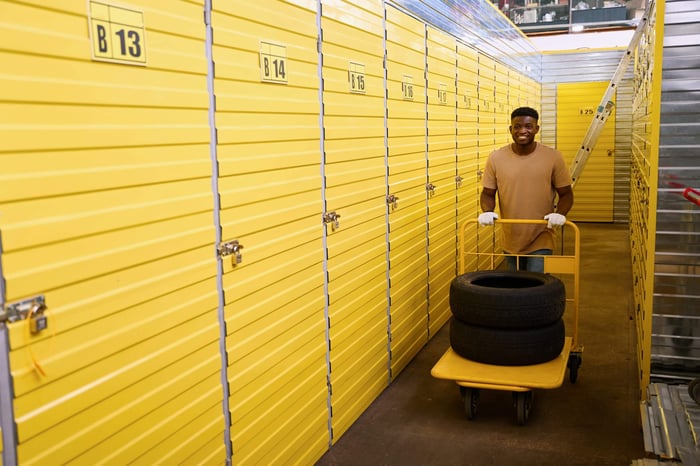 Business storage in Beaumont TX with a worker transporting tires through a self-storage facility