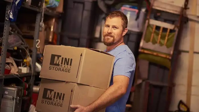 man holding Mini Mall Storage moving boxes for self storage