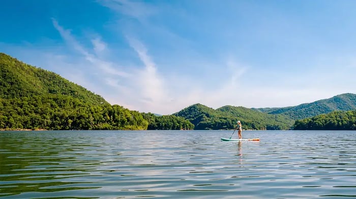 A person paddle boarding on Watauga River