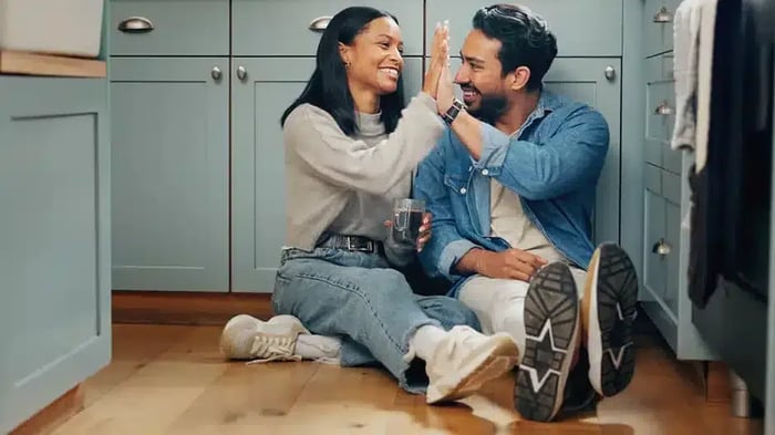 A couple giving each other a high-five after getting all their items from Mini Mall Storage