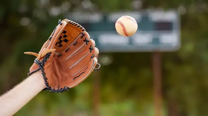 A hand sticking out with a baseball glove, catching a baseball in Fairborn Community Park.