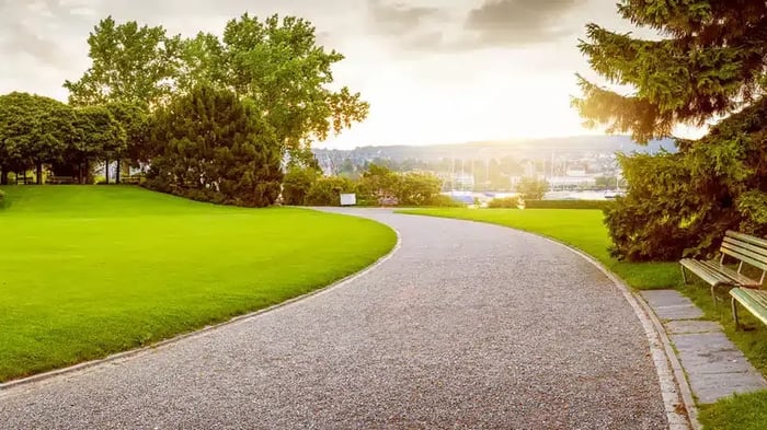A walking path next to green grass overlooking the town of Fairborn, OH