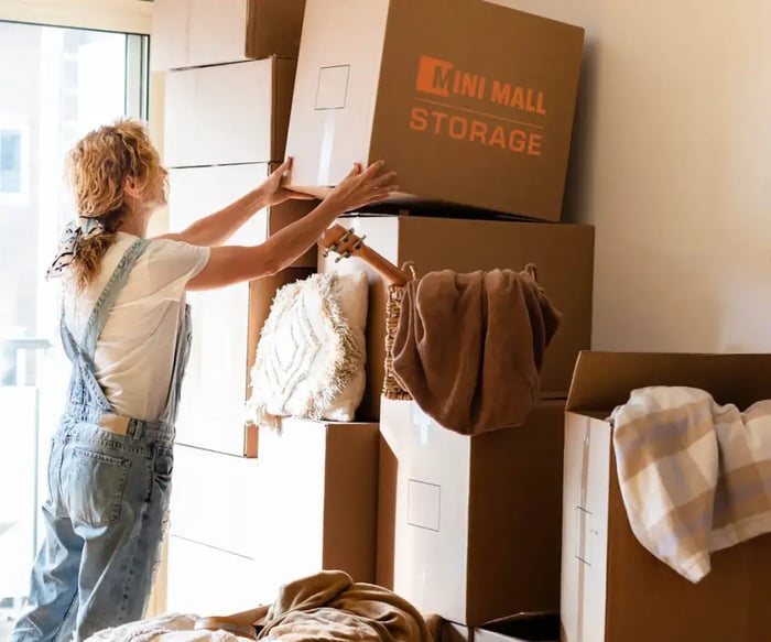 a woman storing seasonal items in Mini Mall Storage moving boxes