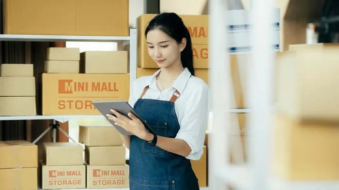 a woman in a Mini mall Storage unit doing inventory