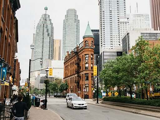A city street with ray car driving down the road