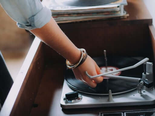 A girl playing a vinyl record in the record cabinet