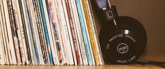Vinyl records stacked vertically, with headphone leaning against them