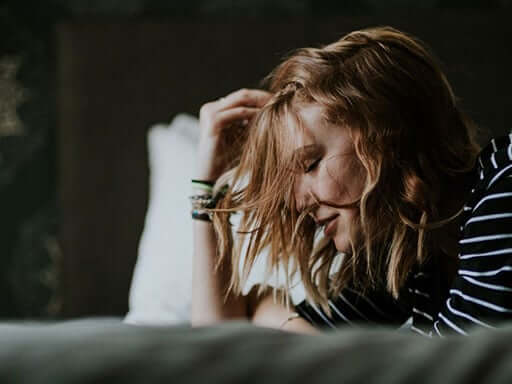 Woman leaning her forehead into her hand
