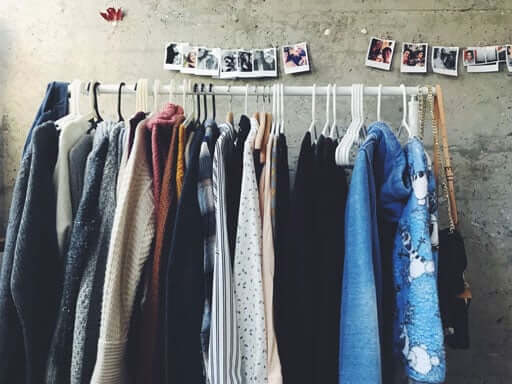 Clothes on rack and photos on wall
