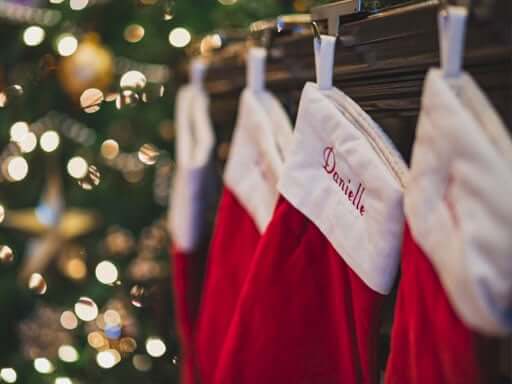 A row of red stockings hanging on a mantle