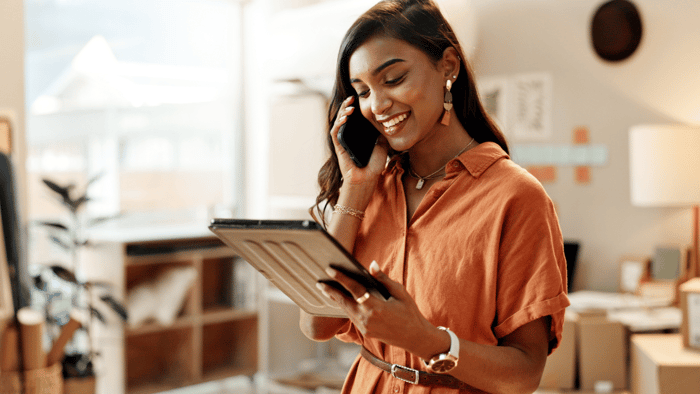 Woman asking questions by phone while reviewing rental information on a tablet