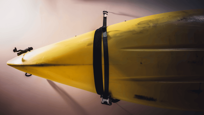 Yellow kayak supported horizontally on a wall-mounted storage rack
