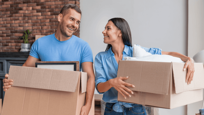 Two people packing household boxes before moving belongings into storage