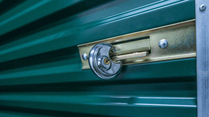 Storage unit lock installed on the latch of a roll-up storage door