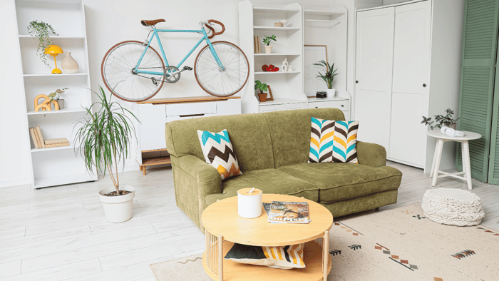 Wall-mounted bicycle and tall shelving creating vertical storage in a small apartment