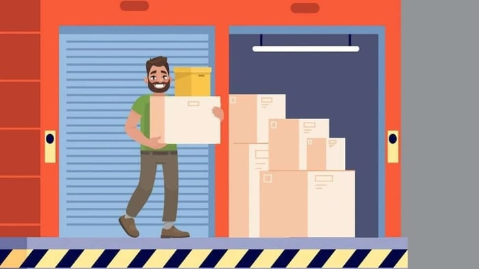 A cartoon of a man moving boxes into a storage unit.