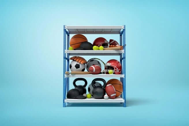 Basketballs, footballs and other sports equipment on a shelf.