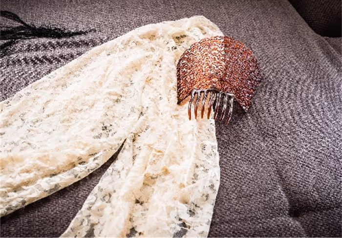 One of the most iconic uses of Spanish lace is the "Mantilla", a lace veil traditionally worn by women in Spain. Mantillas are made from fine white or black lace