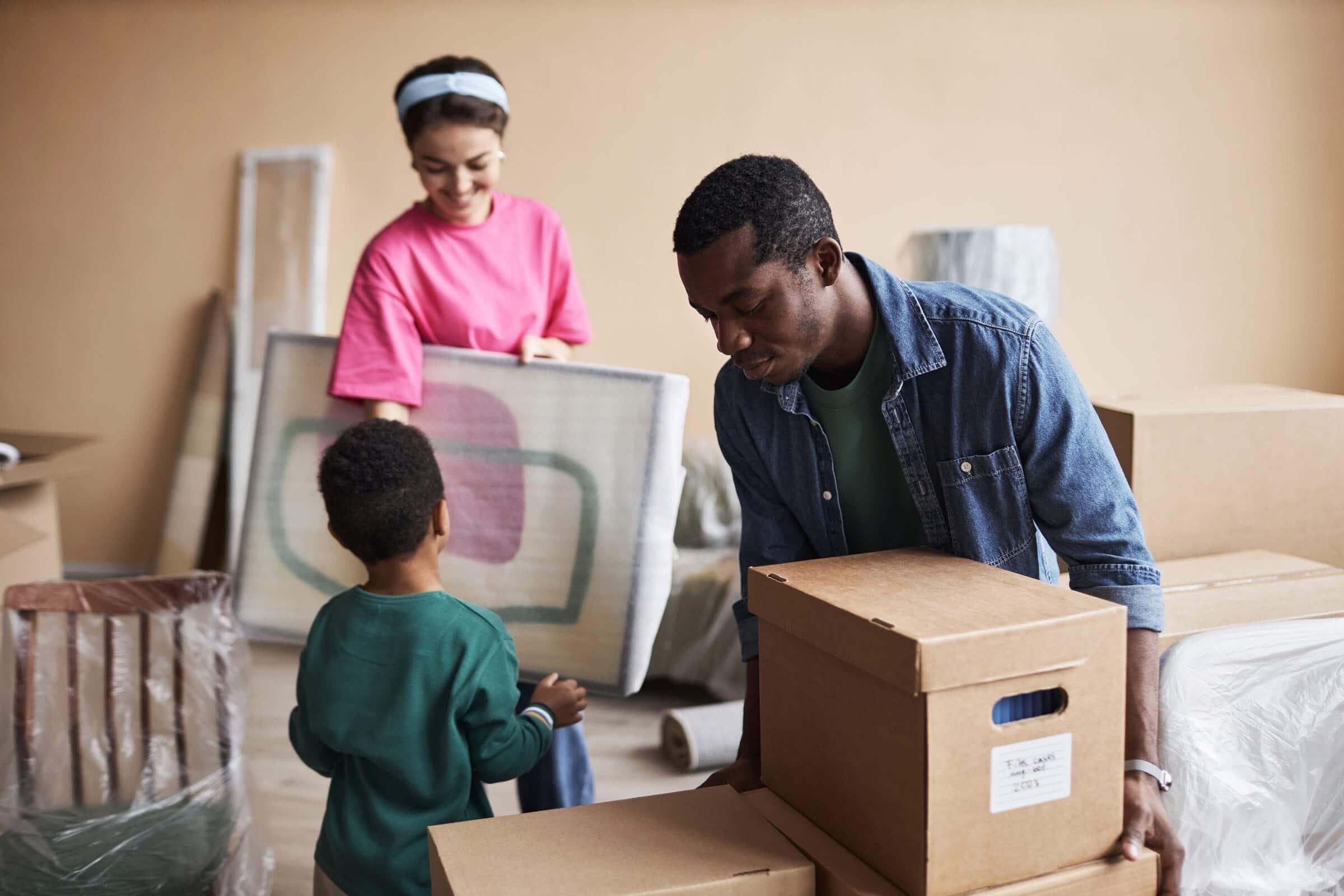 Couple and child packing moving boxes for self storage units Charlotte